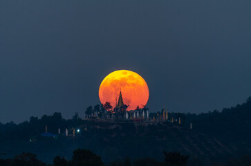 The moon rises behind Phra That Nang Khoi, Chiang Rai, northern Thailand.