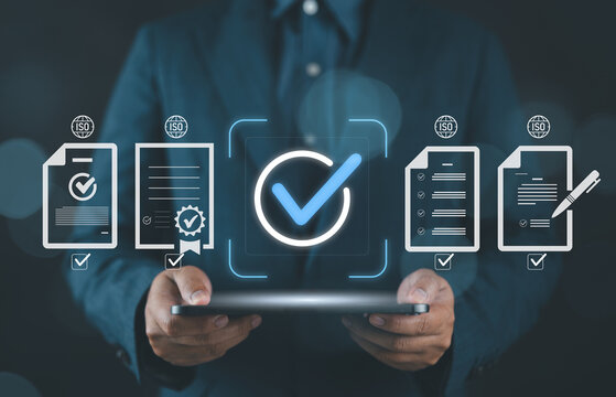 Businessman holding a tablet with digital ISO certification icons, representing quality assurance, compliance management, document approval, standardization, data security, and process control.