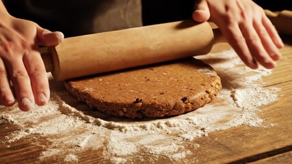 Hands expertly roll out dough on a wooden table dusted with flour. The warm atmosphere and cozy surroundings add to the excitement of baking delicious sweets for the season.