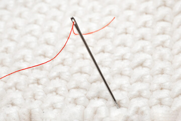 Close-up of a needle with red thread