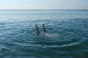 The feet of a drowning child sticking out of the water