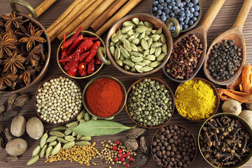 Spices and herbs in metal bowls and wooden spoons. Food and cuisine ingredients
