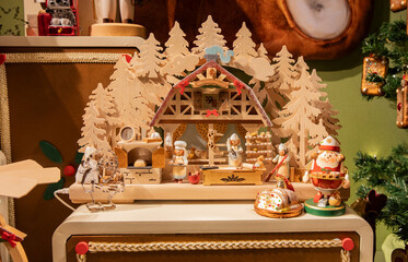 A traditional German wooden nativity scene/bakery with elf figurines and Christmas trees.