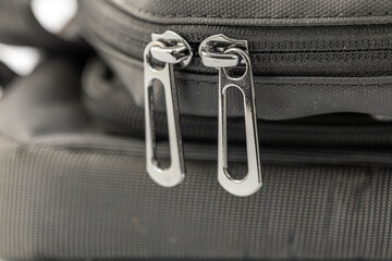 Close-up of stylish metal zipper pulls on a black fabric bag