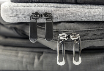 Close-up of zipper details on stacked bags highlighting vibrant textures