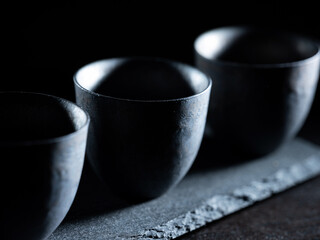 Black teacup on dark background,