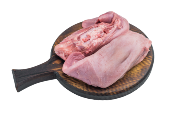 Raw pork tongues placed on round wooden board over white background fresh organ meat ingredient for traditional cooking.