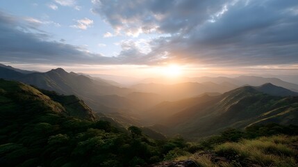Majestic mountain range bathed in the warm golden light of a dramatic sunrise with layers of peaks receding into a hazy horizon
