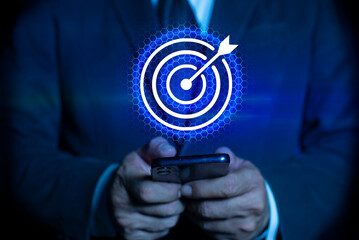 Man holding smartphone displaying holographic financial growth target business finance. Concept of suggesting business growth and performance analysis