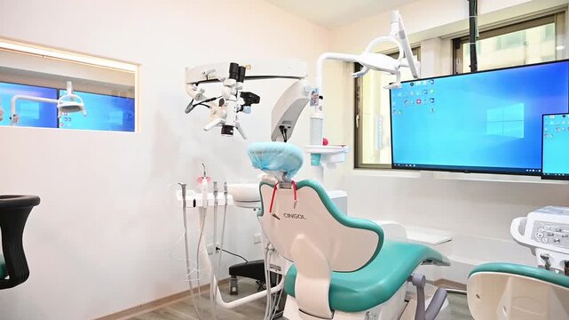 A modern dental operatory with a turquoise dental chair, instrument console, and microscope, revealed through a near-to-far camera move