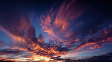 Fototapeta premium Brilliant colors fill the sky as the sun sets creating a stunning display of clouds in vibrant hues. The scene captures the beauty of nature at dusk inviting peaceful reflection.