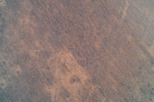 Abstract aerial view of a plowed agricultural field with subtle textures and isolated traces of shell explosions. - Powered by Adobe