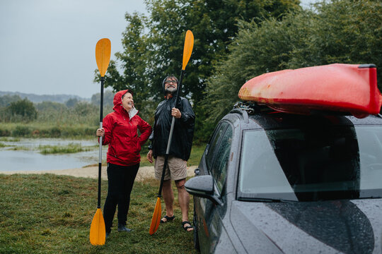 Senior couple enjoying rainy day kayaking adventure