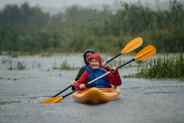 Senior couple kayaking enjoying rainy weather outdoor
