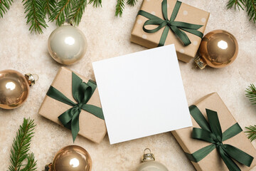 Christmas greeting card mockup with blank copy space surrounded by beautifully wrapped gift boxes and festive ornaments, creating a warm holiday atmosphere