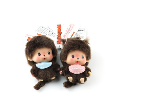 a popular classic doll toy , Monchichi or Monchhichi , Japanese cute monkey fur doll display on white table with white wall background in souvenir tourist shop in Japan