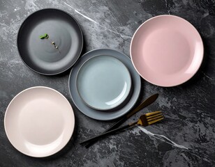 Overhead shot of five ceramic plates, arranged on a marble surface with silverware