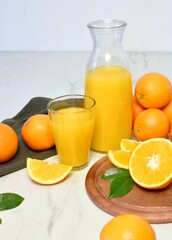 Oranges and orange juice, rich in vitamins and rich in nutrients, are on the table.