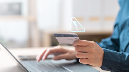 Person holding credit card with virtual warning icon, representing fraud alerts and digital security risks. Suspicious charge fraud alert. symbolizing fraud alerts and secure transaction monitoring.