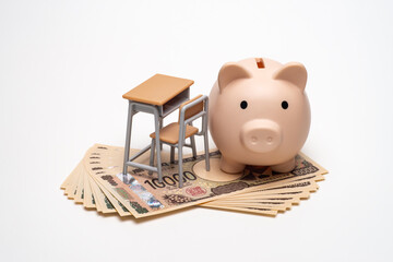 豚の貯金箱と紙幣と机で教育費のイメージ