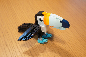 Obraz premium A colorful Lego toucan bird model on a wooden surface