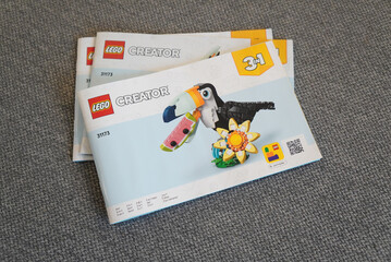 Obraz premium Lego Creator 3-in-1 Toucan Building Set Instruction Manuals on a Gray Surface