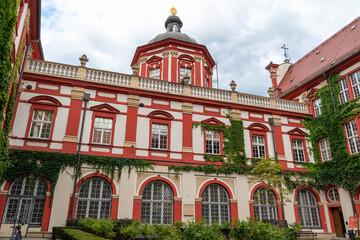 Historic red and white baroque building with ivy-covered walls. Ossoliński National Institute