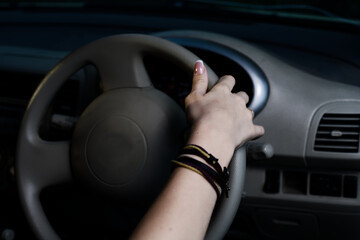 Close-Up of Woman's Hand Steering Car Wheel at Night, Emphasizing Drive and Control in a Vehicle