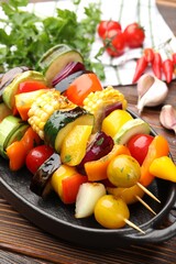 Skewers with tasty grilled vegetables on wooden table, closeup