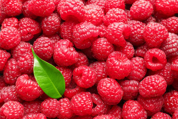 Fresh ripe raspberries and leaf as background, top view