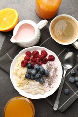 Healthy breakfast. Oatmeal with nuts, berries, yoghurt, chia seeds, coffee and orange juice on grey textured table, flat lay