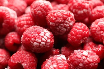 Frozen ripe raspberries as background, closeup view