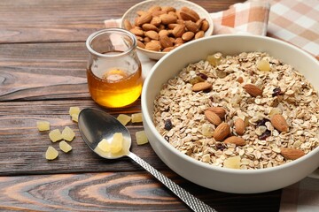 Making granola. Oat flakes, dried fruits, almond nuts and honey on wooden table, closeup