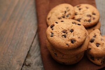 Yummy chocolate chip cookies on wooden table, closeup. Space for text