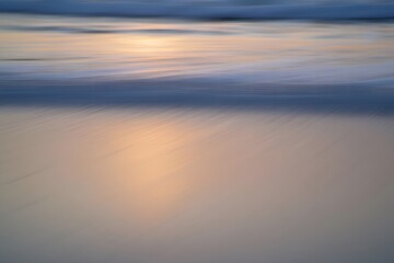 Soft sunset reflection on calm water surface