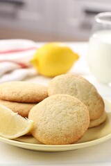 Tasty lemon cookies and fruits on white wooden table, closeup