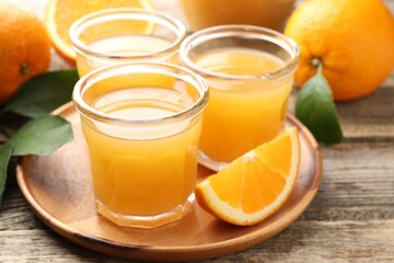 Fresh orange juice and fruits on wooden table, closeup