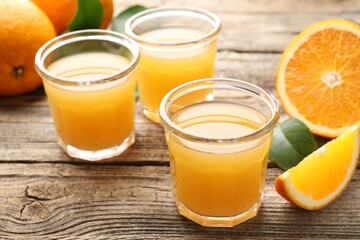 Fresh orange juice and fruits on wooden table, closeup
