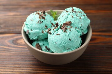 Tasty mint chocolate chip ice cream on wooden table, closeup