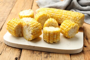 Pieces of boiled corn cobs on wooden table, closeup