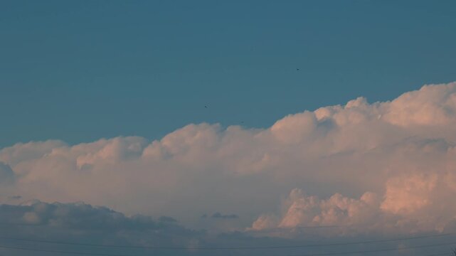 Timelapse di nuvole che si formano e si spostano nel cielo, al tramonto, con colori brillanti
