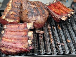 Thick steaks and giant ribs cooking on the grill 