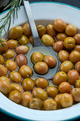 Green Olives in Olive Oil with Spoon and Rosemary