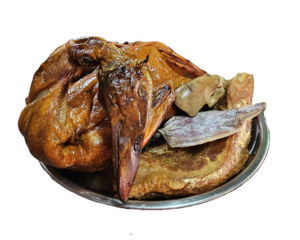 Isolated studio image of traditional Chinese New Year offerings featuring a whole roasted duck, sliced roasted pork, and dried squid for ancestral worship and festive ritual use.