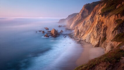 Obraz premium Coastal Cliffs Meet Soft Ocean Waves at Dusk