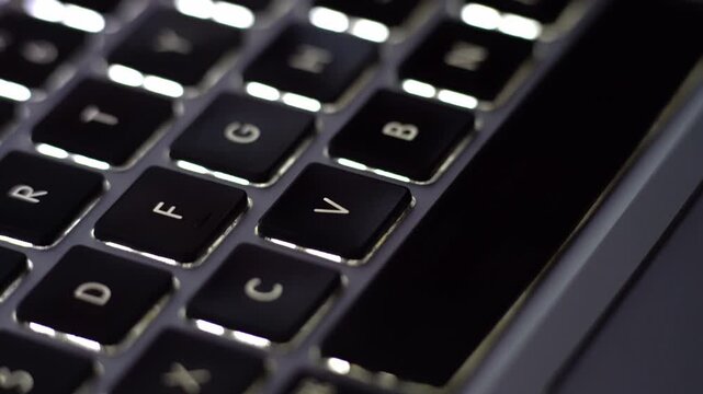 Close-up of a keyboard with English backlit keys, showcasing sharp details and vibrant lighting, perfect for tech, typing, and computer-related visuals