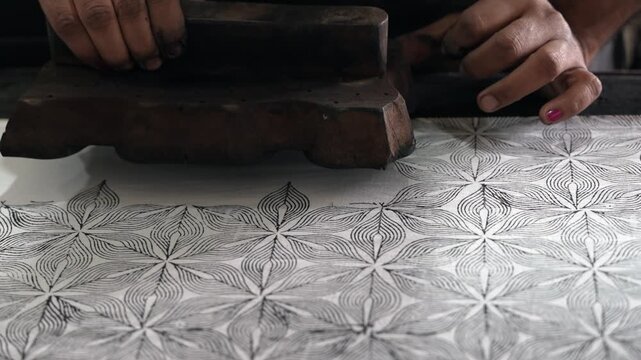 Close-up of Artisan Creating Black Geometric Pattern via Hand Block Printing