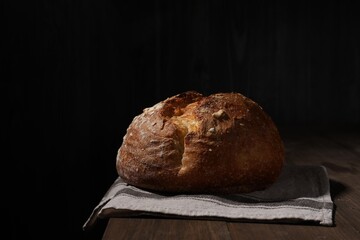 Delicious fresh bread loaf on wooden table, space for text