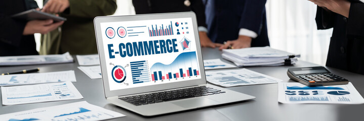 Panorama shot analyst team utilizing BI Fintech to analyze financial report with laptop. Businesspeople analyzing BI data dashboard displayed on laptop screen for business insight. Prodigy