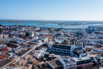 Obraz premium Visitors can enjoy views of the Algarve region from the Old Town of Faro. The Ria Formosa and nearby docks offer a glimpse of local life and activities